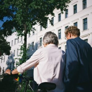 a man and a woman riding a bike down a street